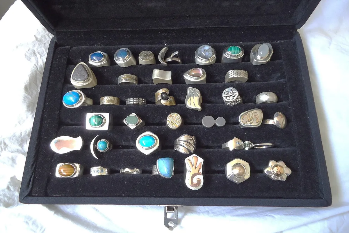 A velvet jewellery box holding a tray of silver rings