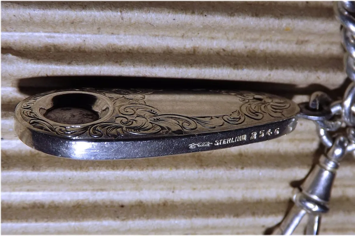 The sterling hallmark and maker's mark stamped on a silver fob